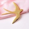 broche dorée arven en forme d'hirondelle