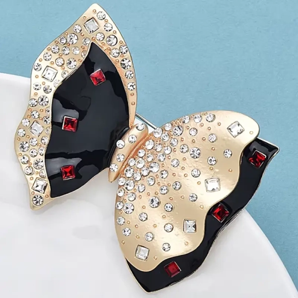 Accessoire mode femme : broche nœud noir et or idéale pour un look couture ou une veste chic
